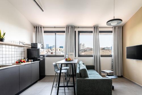 a kitchen with a couch and a table in a room at HA MESILLA - Modern Collection - By HOMY in Tel Aviv