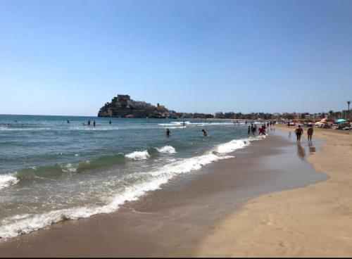 plaża z grupą ludzi w wodzie w obiekcie cala josep w mieście Peñíscola
