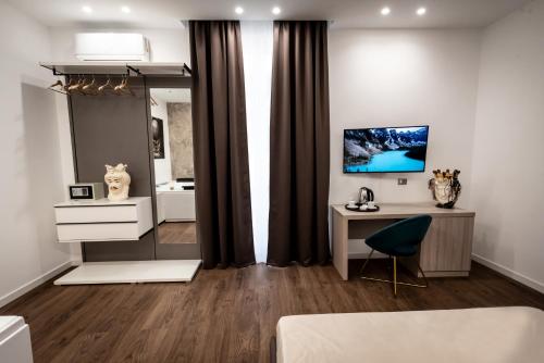 een woonkamer met een bureau en een spiegel bij Fervore Luxury Rooms in Palermo