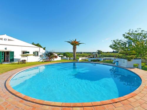 フゼタにあるHoliday Home Quinta da Murteira - FUZ101 by Interhomeの青い大型スイミングプール(レンガ造りのパティオ、家付)