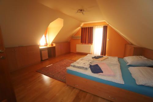 a bedroom with a bed with a rug and a window at Ádám Vendégház Kerekegyháza in Kerekegyháza