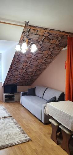 een slaapkamer met een bed en een stenen muur bij Vénusz Apartman in Cserkeszőlő