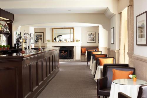 a restaurant with a bar with chairs and a fireplace at The Royal Hotel in Ventnor