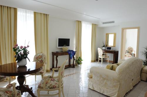 a living room with a couch and a table and chairs at Hotel Villa Fraulo in Ravello