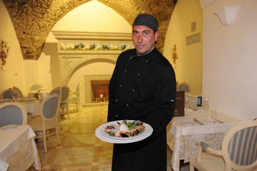 a man is holding a plate of food at Hotel Villa Fraulo in Ravello