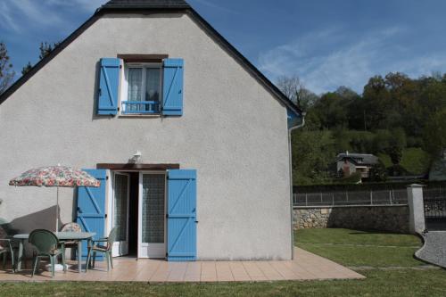 a house with blue doors and a table and chairs at Gite Ladagnous in Peyrouse