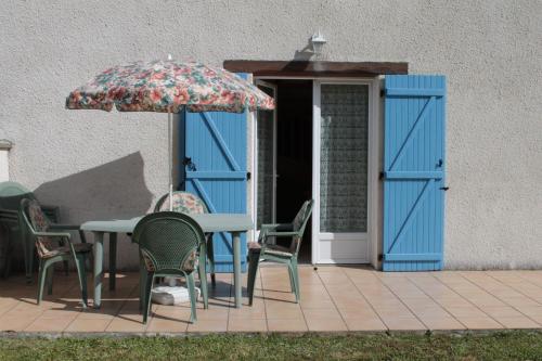 a table and chairs and an umbrella on a patio at Gite Ladagnous in Peyrouse