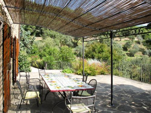 patio con tavolo e sedie sotto un pergolato di Holiday Home Bramasole by Interhome a Cortona