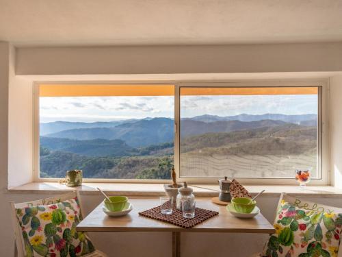 un tavolo con vista sulle montagne da una finestra di Holiday Home Agapanthus by Interhome ad Arnasco