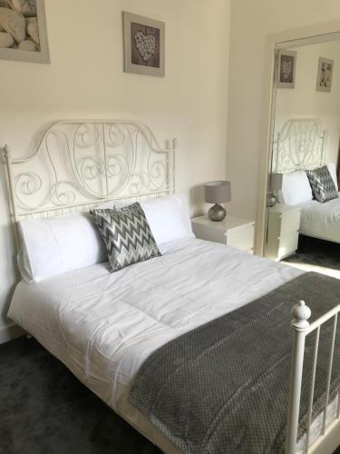 a bedroom with a white bed and a mirror at Apex Variety Gate Apartment in Glasgow
