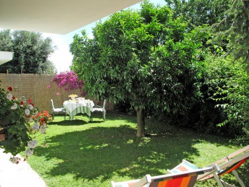 un jardín con una mesa y un árbol en el patio en Apartment Mandarino by Interhome en Montignoso