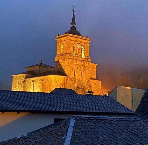 a large tower with a clock on top of a building at SEÑOR OSO in Molinaseca