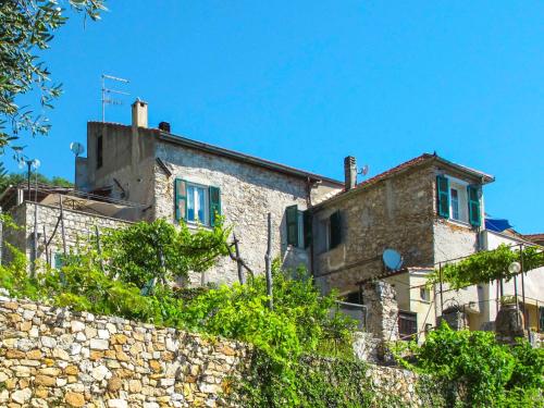 uma casa de pedra com janelas azuis e uma parede de pedra em Apartment Olivotto - FLG147 by Interhome em Finale Ligure