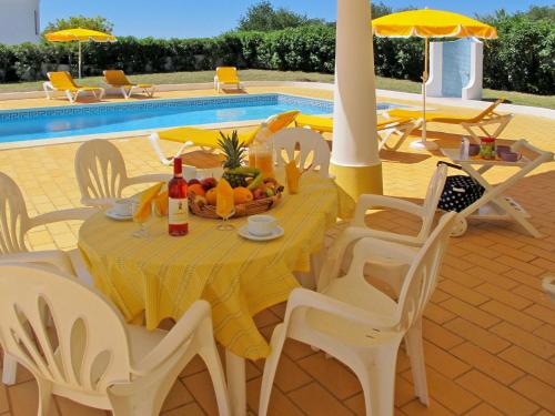 a table with a bowl of fruit on it next to a pool at Holiday Home Da Bela Vista - PAD110 by Interhome in Paderne