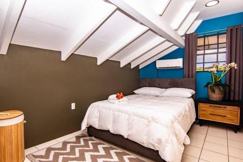 a bedroom with a bed with white sheets and blue walls at CityLife Apartments in Historic Willemstad - 2 bedroom apartment - K in Willemstad