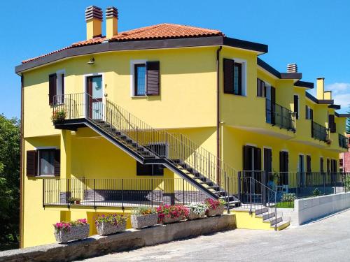 une maison jaune avec des escaliers devant elle dans l'établissement Apartment Sambucco - SBO102 by Interhome, à Savone