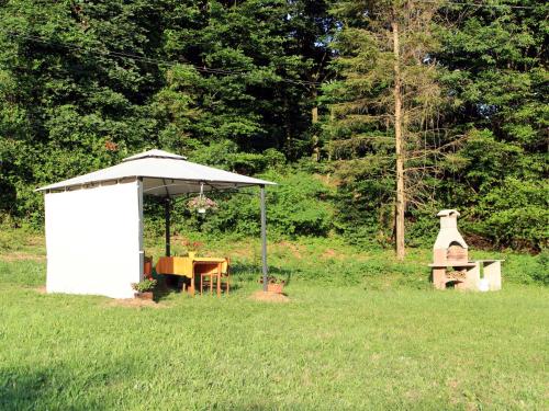 a white shed in a field with a table and a grill at Apartment Sambucco - SBO102 by Interhome in Savona
