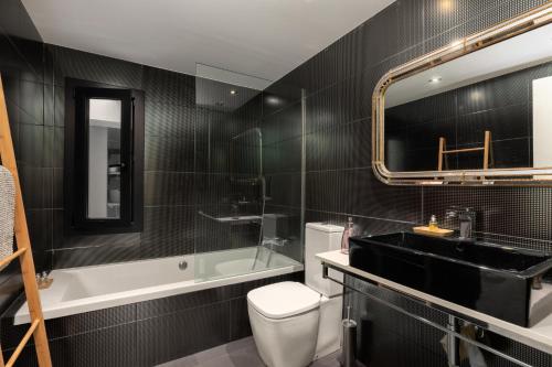 a bathroom with a toilet and a sink and a tub at Casa del Mar in Tamariu