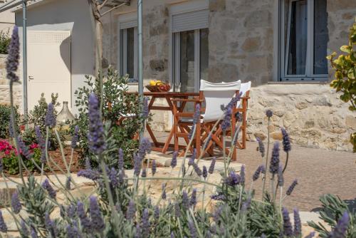 einen Tisch und Stühle in einem Garten mit lila Blumen in der Unterkunft Zeus Traditional House in Mitrópolis