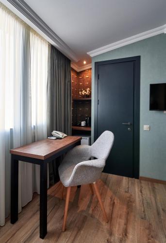 a room with a wooden table and a chair at Hotel City in Tbilisi City