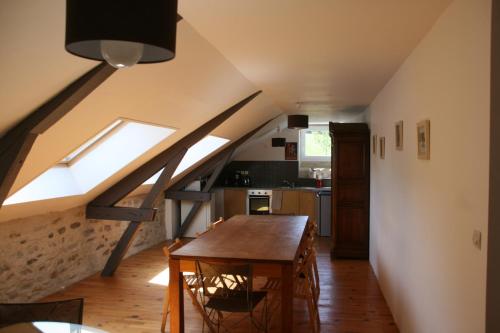 cocina con mesa de madera en el centro de una habitación en Manoir Théas en Barraute-Camu