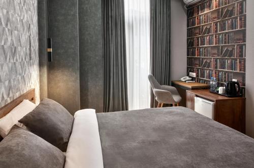 a bedroom with a bed and a desk and a chair at Hotel City in Tbilisi City