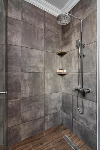 a shower in a bathroom with a tile wall at Hotel City in Tbilisi City