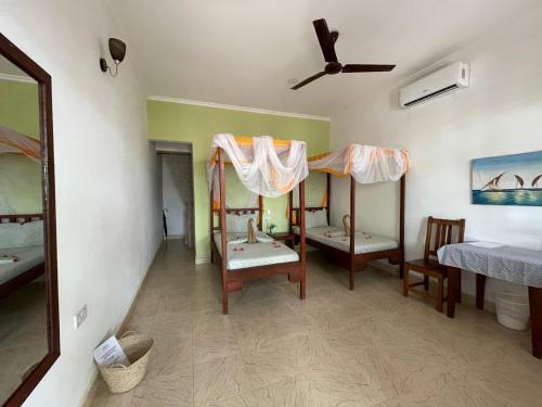 a room with two bunk beds and a mirror at Highland Bungalows in Nungwi