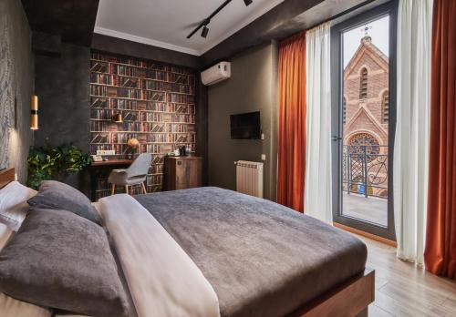 a bedroom with a large bed and a large window at Hotel City in Tbilisi City