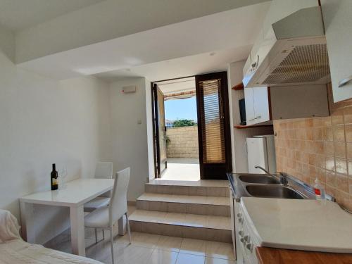a kitchen with a sink and a table with a counter at Apartment Ella in Rab