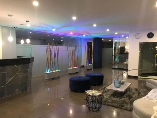 uma sala de estar com luzes azuis e cadeiras azuis em Apartamentos Amoblados-Atlantis Suites Bquilla em Barranquilla