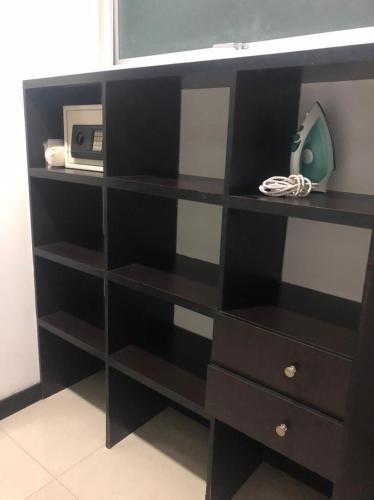 a black book shelf with a microwave on it at Apartamentos Amoblados- Buenavista Barranquilla in Barranquilla
