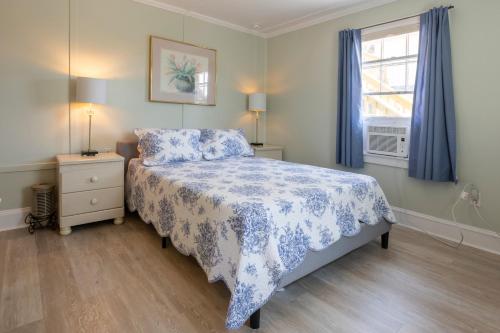 a bedroom with a bed with a blue and white bedspread at Blackbeard's Lodge in Ocracoke