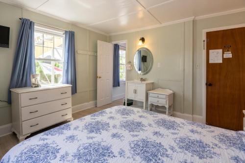 a bedroom with a bed and a dresser and a mirror at Blackbeard's Lodge in Ocracoke