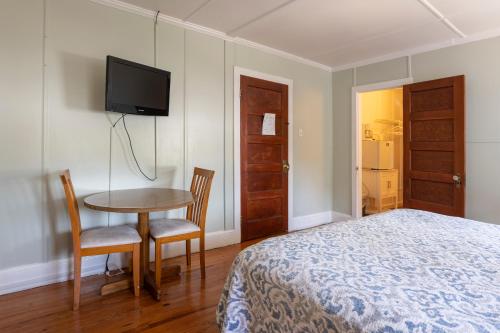 a bedroom with a bed and a table and a tv at Blackbeard's Lodge in Ocracoke