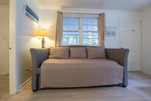 a couch in a living room with a window at Blackbeard's Lodge in Ocracoke