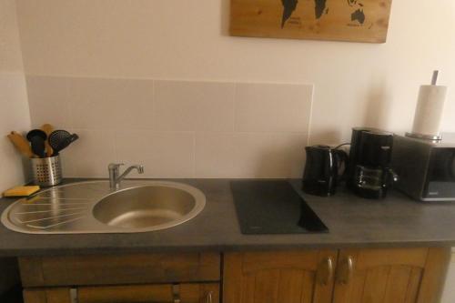 a kitchen counter with a sink and a coffee maker at Gîte L'EAU VIVE in Noyers