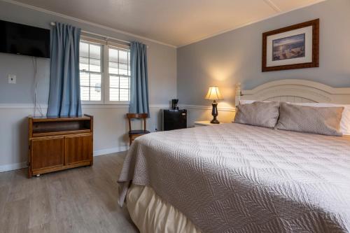 a bedroom with a bed and a flat screen tv at Blackbeard's Lodge in Ocracoke