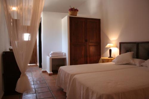 a bedroom with a large bed and a dresser at Cortijo Los Malenos in Agua Amarga