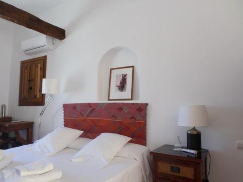 a bedroom with a bed with a red headboard at Cortijo Los Malenos in Agua Amarga