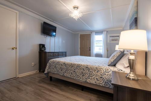 a bedroom with a bed and a table with a lamp at Blackbeard's Lodge in Ocracoke