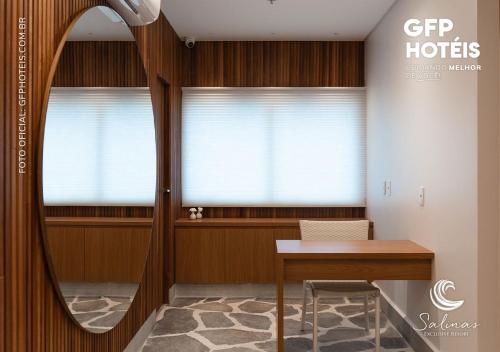 um quarto com uma mesa e duas janelas em SALINAS EXCLUSIVE - GAV Resorts em Salinópolis