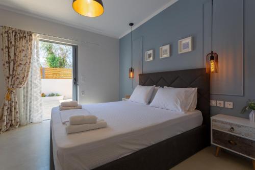 a bedroom with a large bed with two towels on it at Amoroza Villa in Nydri