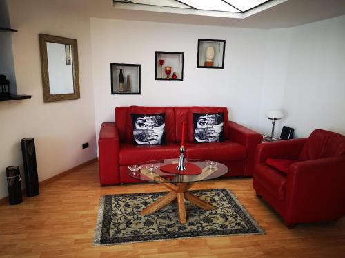 ジェノヴァにあるCorte Lambruschini central apartment with Free covered Parkingのリビングルーム(赤いソファ、テーブル付)