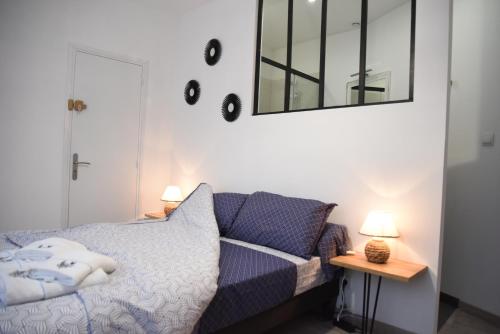 une chambre avec un lit et un miroir au mur dans l'établissement Appartement de charme RDC, à Boulogne-sur-Mer