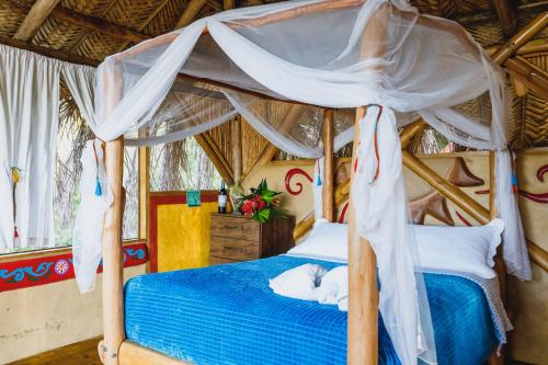 a bedroom with a bed with a white cat laying on it at Sol de Minca Eco Lodge in Minca