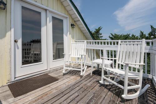 two white rocking chairs sitting on a porch at Blackbeard's Lodge in Ocracoke