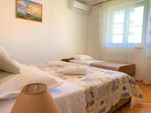 a bedroom with two beds and a window at Roko apartment house in Primošten