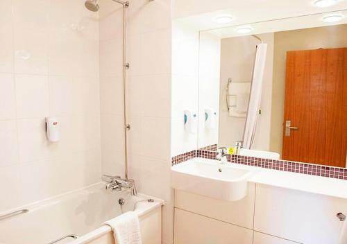 uma casa de banho com uma banheira, um lavatório e um espelho. em Casa Mere Manchester; Sure Hotel Collection by Best Western em Knutsford