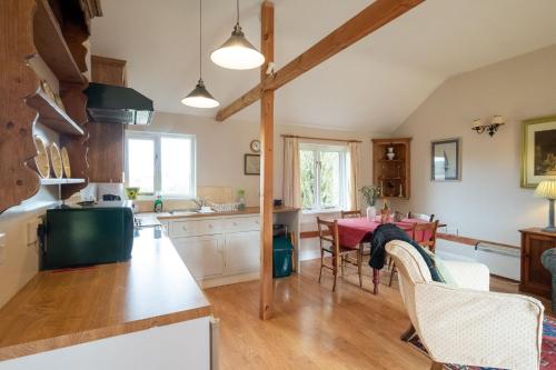 a kitchen and dining room with a table and chairs at The Stables, Theberton in Theberton